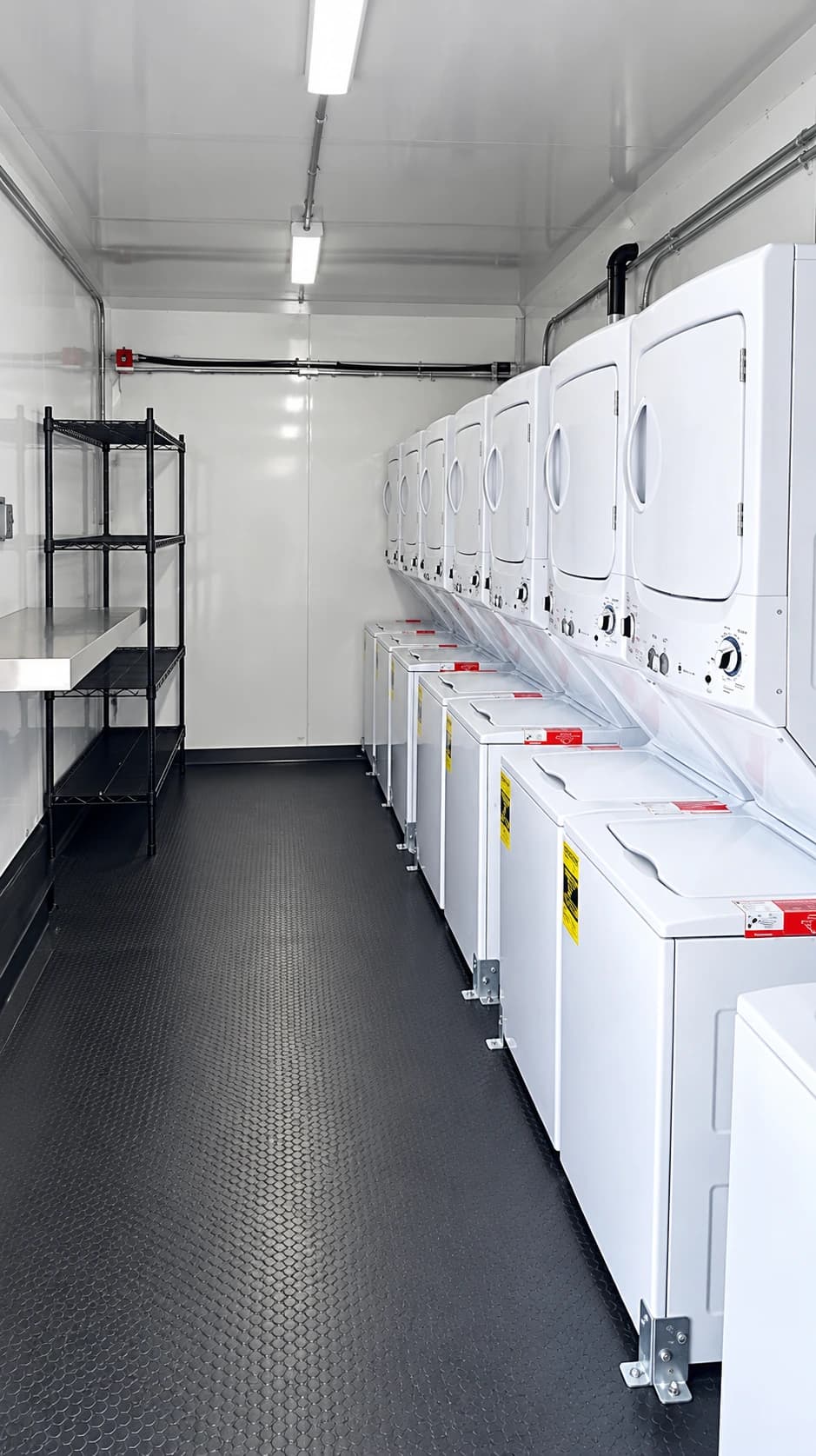 Rows of washing machines and dryers inside a laundry trailer