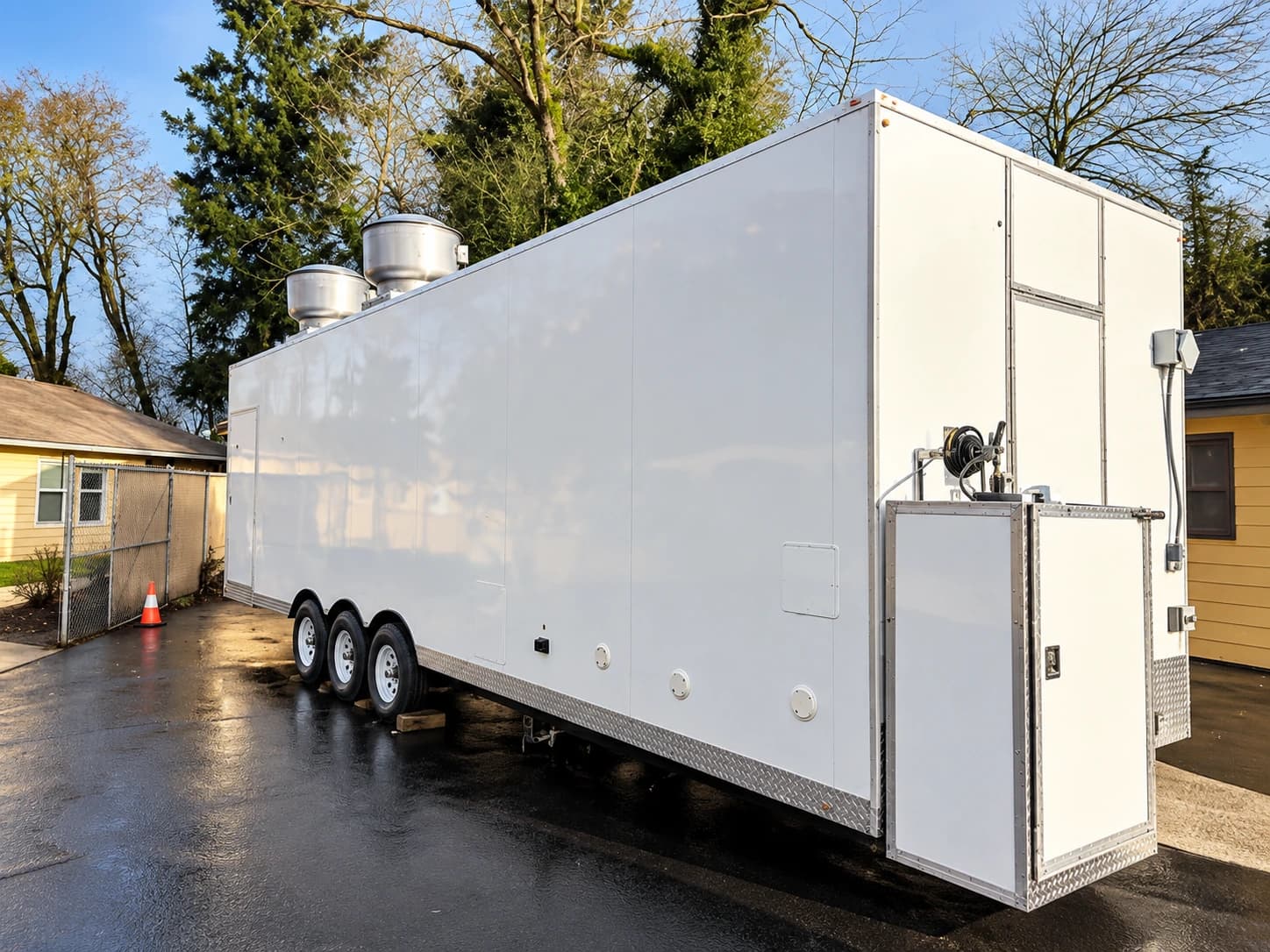 White mobile commercial kitchen trailer with rooftop exhaust equipment
