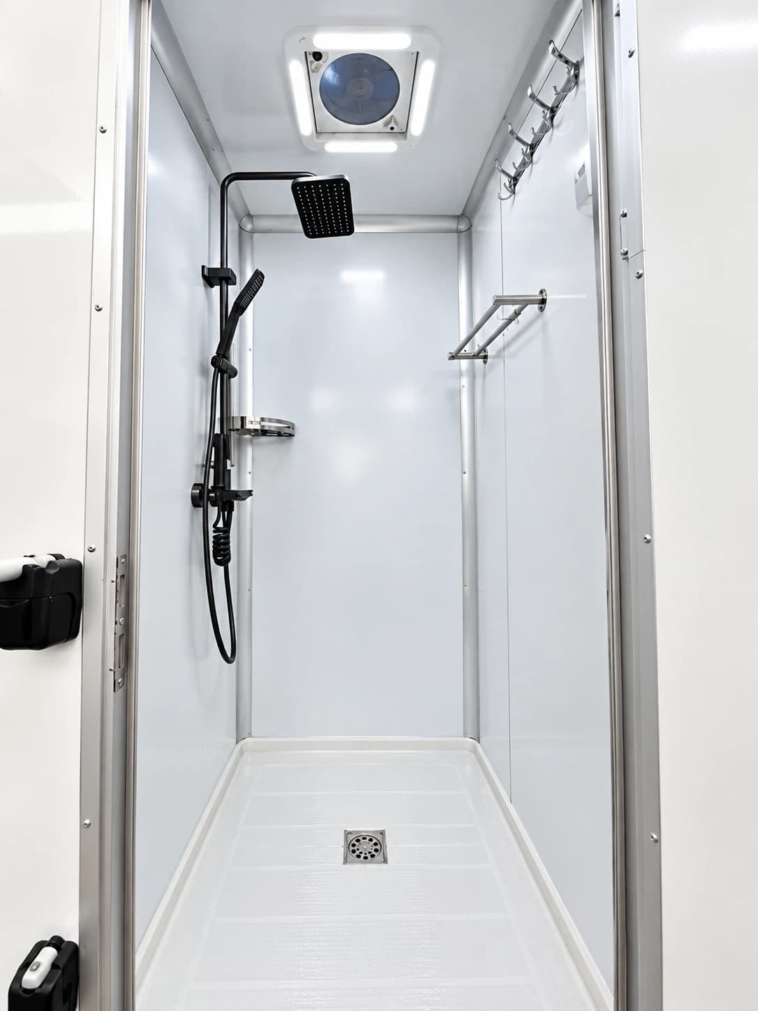 Shower stall with a handheld shower and white wall panels